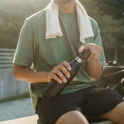 Water bottle and towel on a bench.